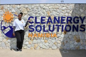 A lady posing for a photo in front of a brick wall