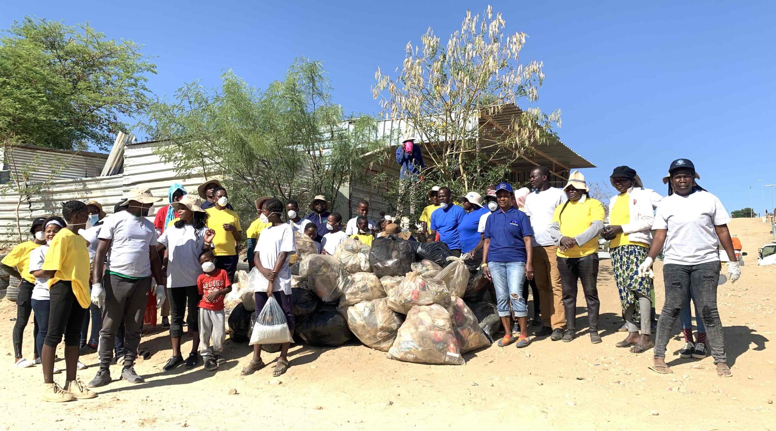 DWN volunteers pose with locals after a community clean up event.