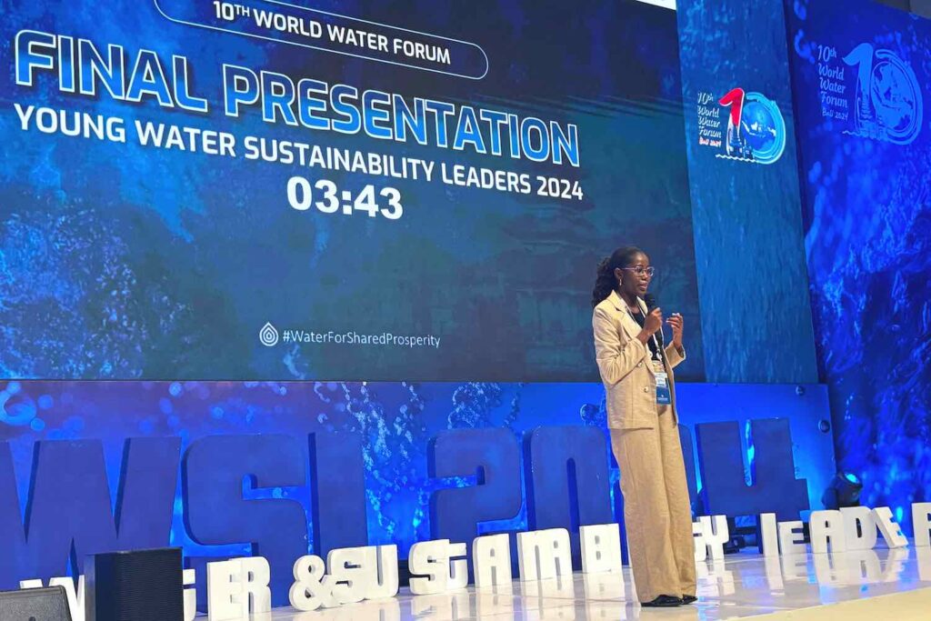 A woman stands on stage holding a microphone.