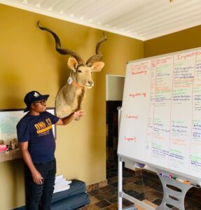 Man, whiteboard, and Kudu trophy.
