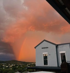 Cloudy sky with a bright rainbow in a city