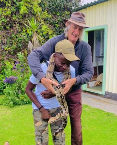 A python snake wrapped around a man's shoulders